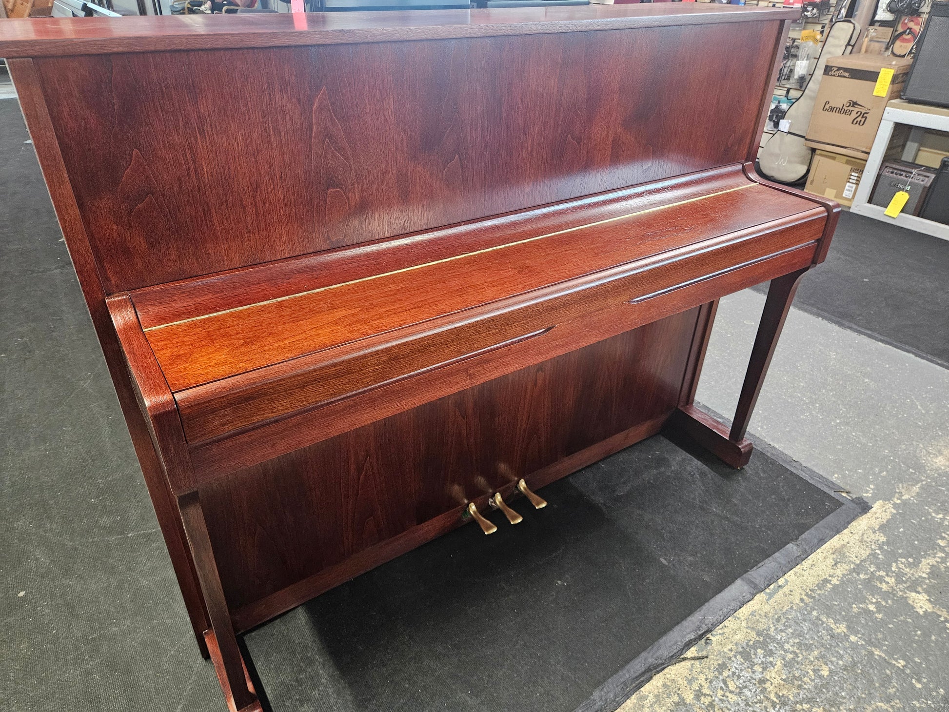 Image of a Kemble upright piano with a refinished mahogany cabinet. Features a closed fall.